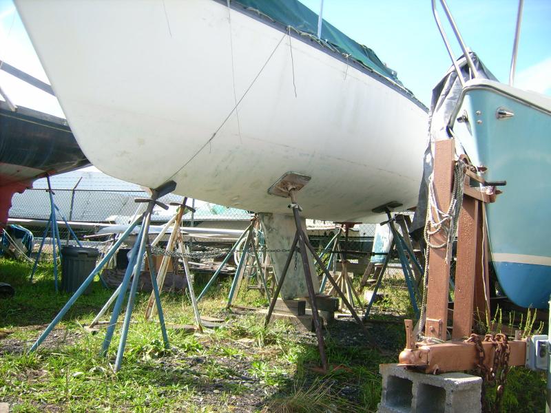 19 September 2012.  Right after I got the last of the bottom down to well-sanded gelcoat.  I love this pic-- the boat looks about ready to fly off the stands.  What a terrific hull shape this little boat has.

(The bow is at a 60-degree angle to the waterline.  This is my dad's trademark with the early Hunters.)