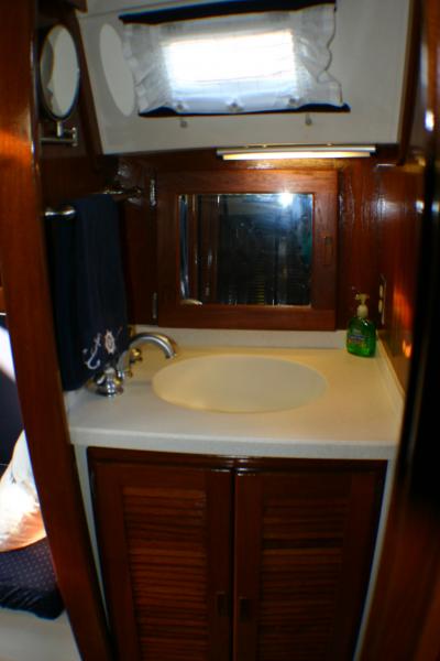 All new surrounding teak veneer paneling and new solid surface with integrated bowl sink. New faucet