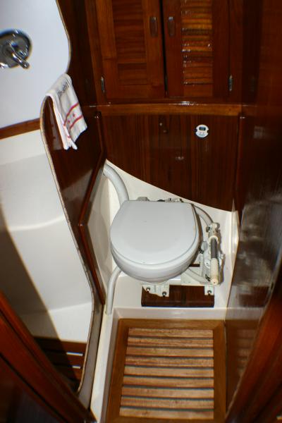 All new teak in the head included a custom made floor mat. TJ raised the toilet by installing teak block for us taller longer legged sailors! Edges of shower still needing to be finished.