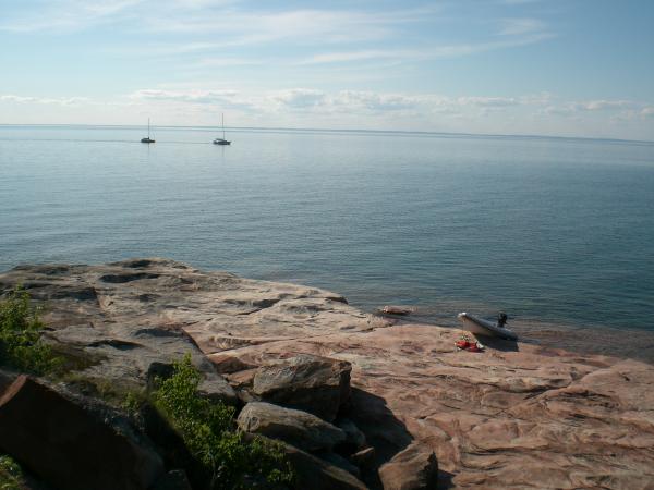 Ashore at Sand Island looking west toward the north shore of Lake Superior.  Boats motoring by on a calm day.