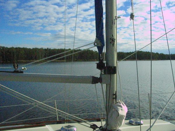 Behind the mast roller furler.