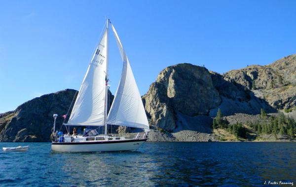 Catherine at the helm as AQUILA cruises past Hell Gate Island named after the radids 300' feet below us under the impounded waters behind Grand Coulee Dam.