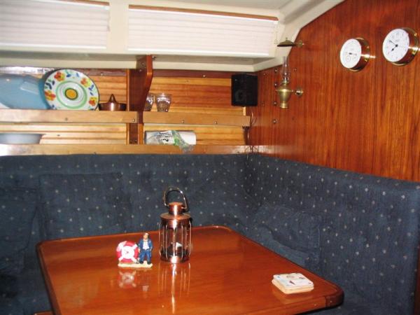 Custom dinette with pedestal table.  Roman shades on new windows.  Pine strips added to hull liner.  Teak fiddles replaced by maple