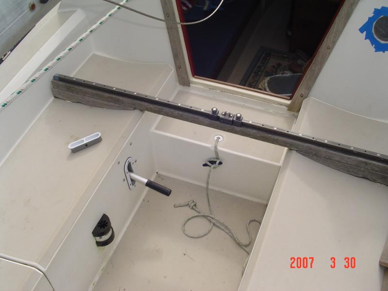 DSC00738 In the picture you see my traveler, and manual bilge pump.  Also pictured is the mount for my galley table which has a similar mount down below on the galley cabinet.
By the way.  I replaced that Nic Fico Traveler with a Harken rope and pulley traveler last summer of 2012.  What a difference that made on my boat!  
  The pump handle is detachable and the plate is inserted back in the hole.  I've never had to use this pump.  Thank the good Lord for small favors.