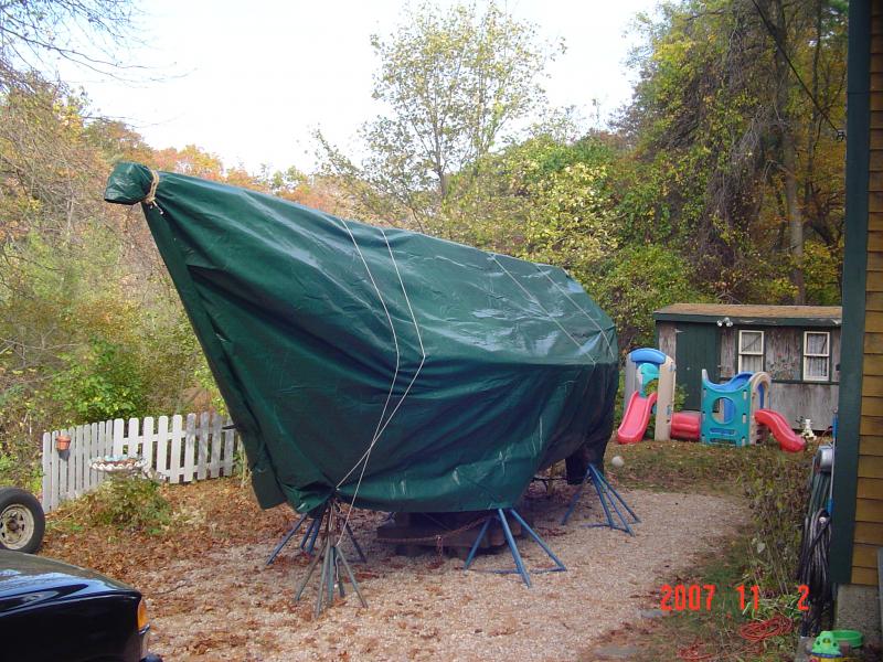 DSC00924  I never had much luck with tarps until I came up with this method of securing the tarp. A picture is worth a 1000 words so check it out.
The tarp is first draped over the mast with the ends even on all sides.  I folded the tarp over the tabernacle an tied a clove hitch with a couple of half hitches.  Whatever excess I had left in my 3/8&quot; sling, I went around the mast and tied a square knot to secure it.  
Where the two front flaps hang down, I took a piece of strapping and used it to roll the flaps on.  I used a carpenter's spring clamp to secure it.