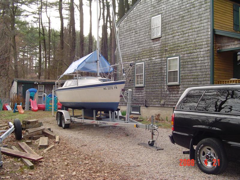 DSC01032 Each spring after getting her bottom painted and loaded back on the trailer, I get the mast up.  If some metal crook want to take this mast he's going to have to take it down.  
Anyway, I always mount the boom and set up a tarp over it so I can work on the boat in days of inclement weather.  The tarp also keeps the dew and the leaves out.