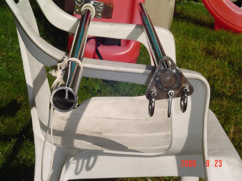 DSC01153 This pic shows the collar and the end of the Gin pole where the bridle connections are made.  In case you're wondering, that triangular plate used to be attached to my backstay and I finally found a better use for it.      I use the top hole to snap on my Jib halyard, and the middle shackle on the bottom is used for my boom vang attachment.   The pulling block of the boom vang of course is connected to the aft hole of my bow stem chainplate.  I unbolted the cam on the pulling block and inverted it so that I could snub the line off by pulling up on the line instead of pulling down on it.