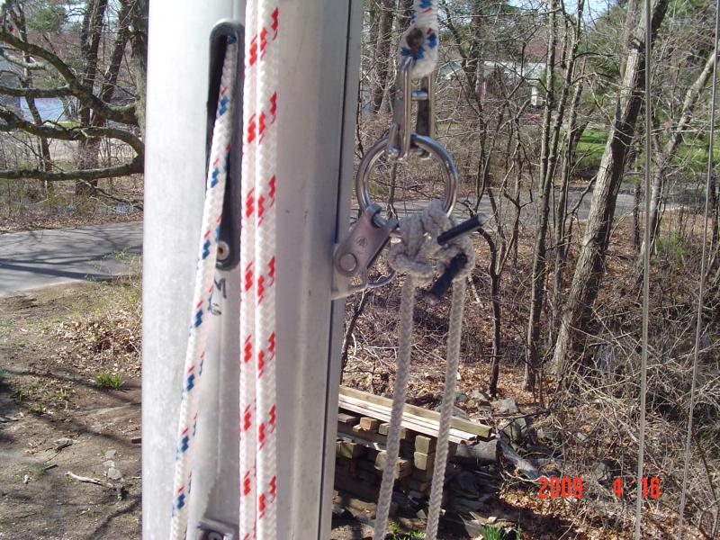 DSC01268  This is another method of attaching the baby stays to your mast.  I tried it for one season and abandoned it for the mast yoke.  Some dude wrote and article in Small Craft Advisor on mast raising and this is one of his &quot;brain children.&quot;    In essence what you see here is a S.S. ring attached to a sail slide in the mast track.  The baby stays are tied to the ring and then snapped into the rings of the pivot bridles on both sides of the boat.   The Main Halyard is attached to the ring and pulled up, cleated off at the bottom of the mast to tension the baby stays.   I really found that setting this up was a big PITA.  No hard feelings to the writer of the article but I'll stick with my mast yoke.  Don't get me wrong.  These are all good ideas.  Try them out and if you like them, adopt them.  There's always something better and easier though.  You just have to come up with the idea.