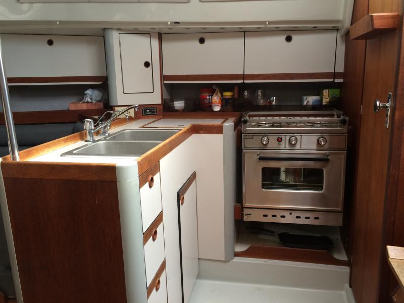 Functional galley with LPG Stove/Oven, refrigerator and double-bowl sink.
