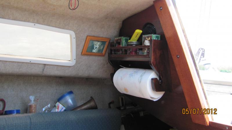 IMG 0001 While I was working on cutting that bulkhead for my boat hook and whisker pole, I built this combination shelf/towel rack and secured it to that bulkhead by the companionway.   You can see my boat hook in the pic.  Hey, there's a picture of Penelope!  She's my First Mate don't sha' know. :)