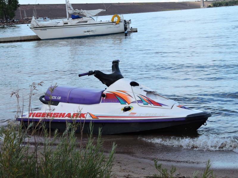 Jet ski, sailboat in background