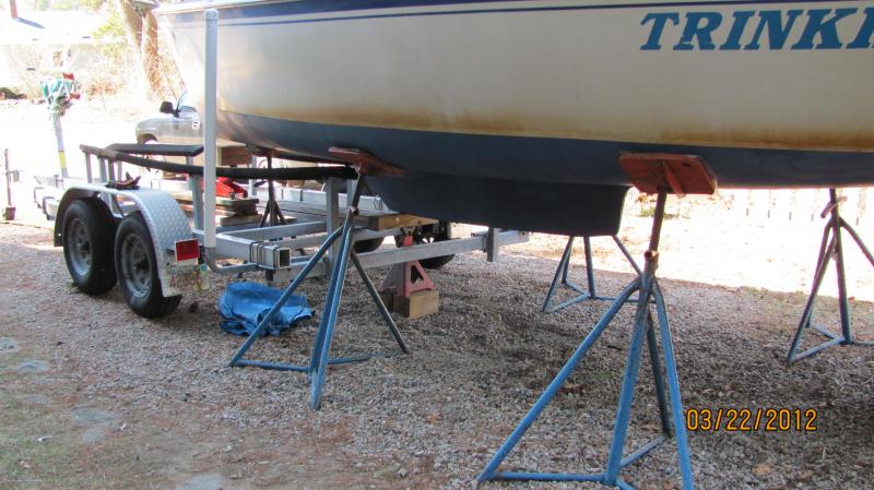 Loading her on the trailer 3 22 12 005 Make sure the boat is high enough to clear the bunks of the trailer.  I've placed a long flat board under the tongue jack wheel of the trailer and I'm pushing the trailer under the hull by hand.  It will roll.