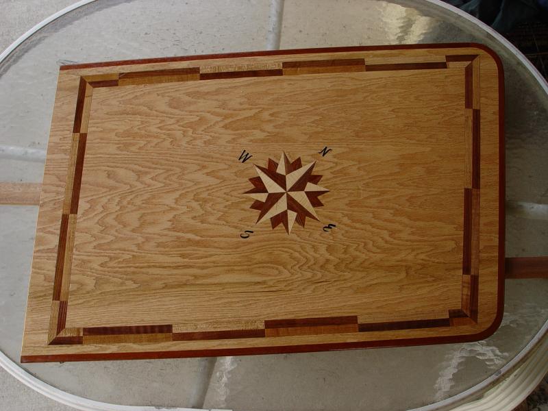 My first attempt at inlaying a dinette table with maple, walnut, mahogany in the compass rose.  Maple/walnut border and mahogany edging.