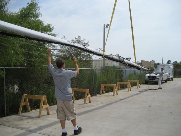 My son Patrick lowering the mast onto the saw horses we made to store the mast on.