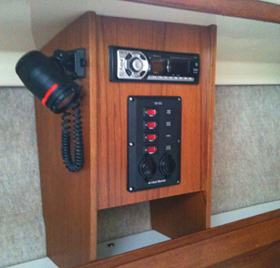 New teak cabinet on port side.  Holds original chart light, new secondary DC panel and AM/FM radio w/ CD player.