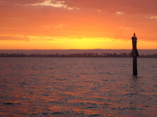 Really cool channel marker sunset picture.