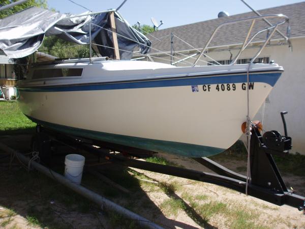 Shortly after it arrived home - you can almost see the damage in the side of the hull where the boat struck a tree while it was being remove from the yard it was stored in. On the ground is the replacement mast I had to acquire from a boat salvage yard...