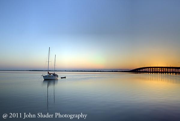 Sometimes I get up early to catch the perfect conditions to take a photo. This image is located near the Eau Gallie Causeway crossing the Indian River Lagoon. I like the sail boat sitting quietly waiting for the sun to raise that the day to begin a new day.