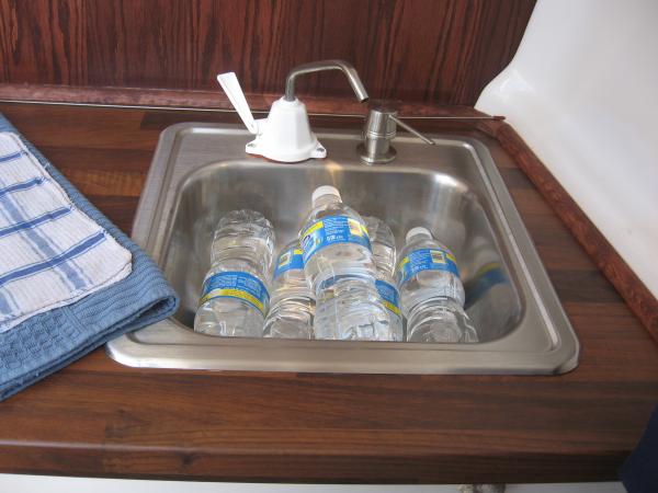 stainless steel sink added and moved to starboard side. It doubles as a cooler during the day