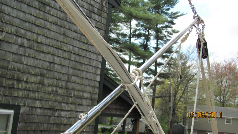 Taking the mast down 004 In this pic you can see the line going around the Vinyl luff and the two half hitches tied around the Gin Pole.  The round turn with the two half hitch are behind the Vinyl Luff in the pic and can't be seen.

If you want to raise/lower your mast with a roller furler all by yourself, this is a pretty nice way to do it because the furler will stay put all the way up or down and this is what you want.   Otherwise, if the furler gets loose and goes over the side, so goes your mast.