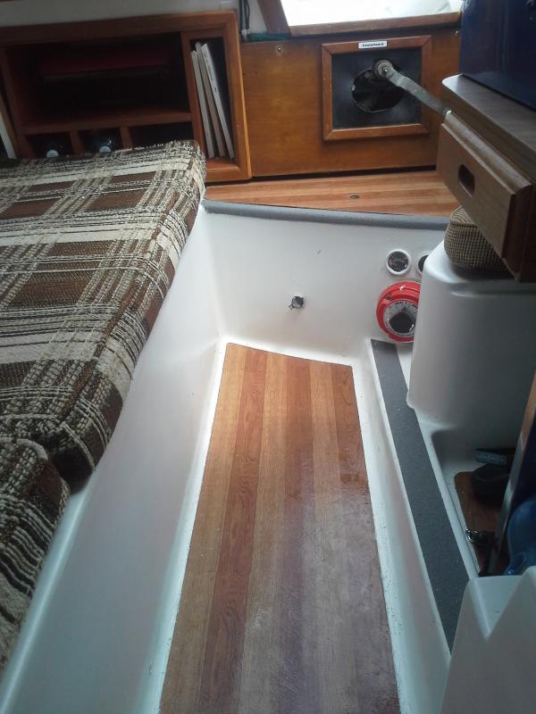 The new laminate vinyl floor. Faux treak tiles laid along the floor and under the dinette table. Also laid onto the companionway step. Looks very chic.