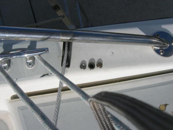 This is on the starboard side, where the autopilot base is set into the gunnel.  The small line is to a Tiller Tamer, which is also used to keep the rudder from swinging while on the trailer.