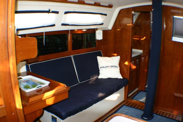 Though new cushions were made of classic navy piped in off white slip covers were made for the bottoms to prolong their life and keep cleaner. Back cushion on port sides were tapered back for more comfort. Custom made shades for fixed ports.