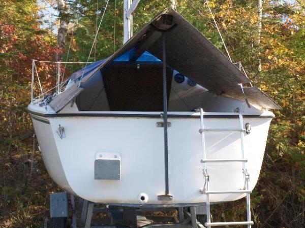 trailer2; I put a long 4x4 timber on the mast crutch. It is held off the cabin forward with a 2x4 at right angles and little 1x2 feet under that. I tack the 3/8 plywood (cut outs for winches and back stays) to the 4x4 every fall with roofing nails. Then cover with a small tarp.