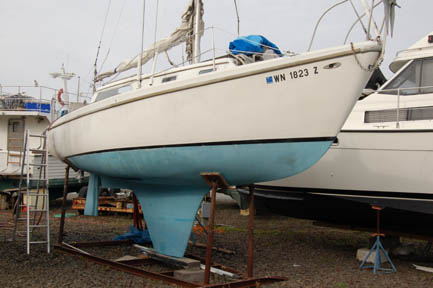 Up out of the water waiting to come home to Seattle. The fin keel is not raked back and there is a little short extension. A firend of ours says it looks like it was made to have an optoin to have an inboard engine.