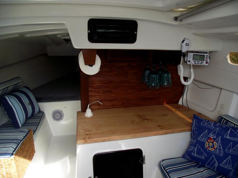 View from companion way, new VHF, radio, countertop, walls, cushions and pillows. Also not shown dual battery switch and 4 toggle fuse panel. The Radio is installed in the smoked plexi-glass. It's also smoked colored. I wanted to be able to take electronics out while in storage.